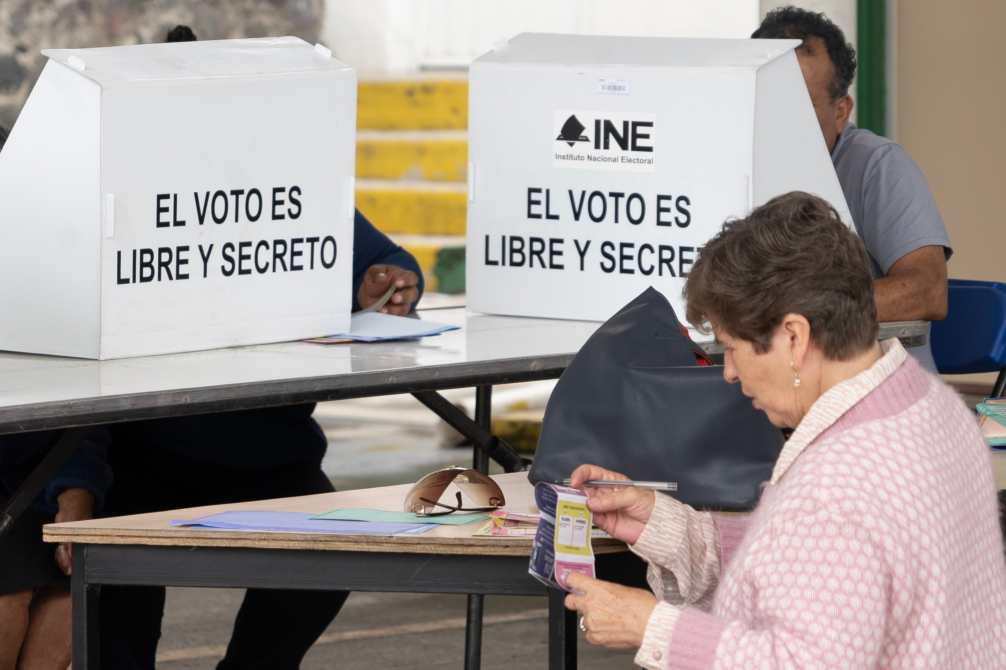 Una mujer consulta su 'acordeón' mientras emite su voto en la elección judicial, el pasado primero de junio.