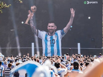 Los argentinos celebran a Messi sosteniendo el Balón de Oro del Mundial a través de una pantalla instalada en Buenos Aires.