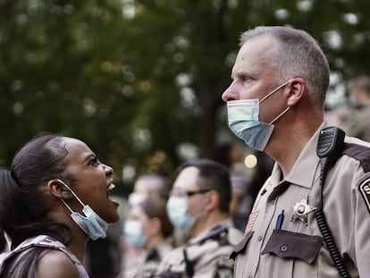 Mulher repreende policial durante os protestos em Minneapolis.