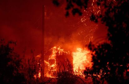 Un cobertizo arde durante el incendio Delta en el bosque californiano Shasta-Trinity.