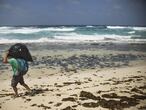 Alexis Rivera, Técnico de Proyectos de la Oficina Regional de WWF en Canarias, carga una bolsa llena de plásticos recogida en las costas de la isla de La Graciosa en el Parque Natural del archipiélago de Chinijos.