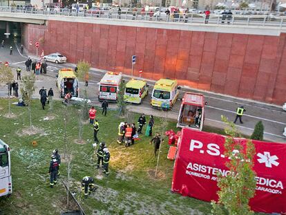 Los servicios de emergencias rodean el autobús accidentado de General Motors, ayer en Zaragoza.
