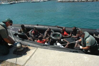 Dos guardias civiles llevan al puerto de Ceuta a inmigrantes que intentaban alcanzar la ciudad a nado.