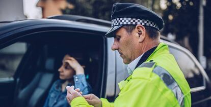 Una mujer es multada por un policía.