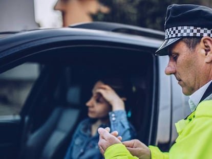 Una mujer es multada por un policía.