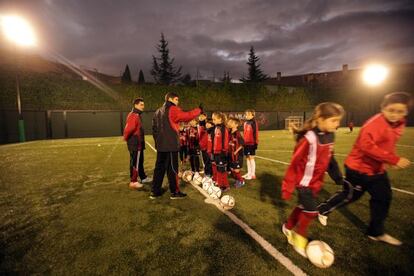 Ni&ntilde;os y ni&ntilde;as se entrenan en un campo de f&uacute;tbol. 