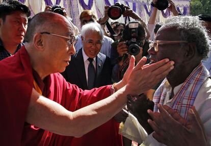 El Dalai Lama acaricia a un hombre enfermo de lepra durante su visita al centro de leprosos de Jaipur, India.