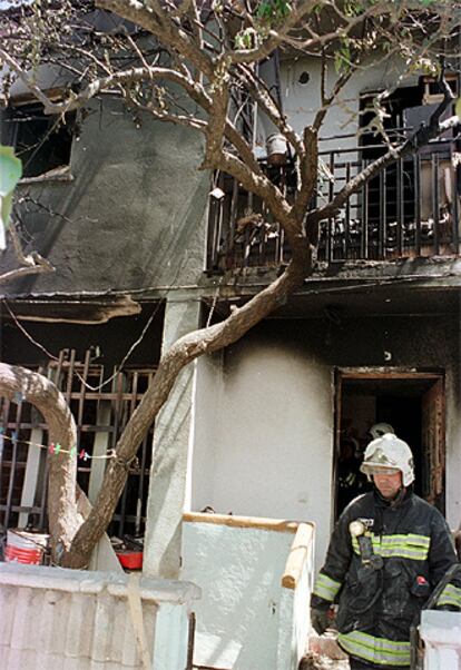 Un bombero sale de la vivienda del barrio pacense del Cerro de Reyes tras el incendio en el que ha muerto la niña.