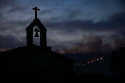 El humo rodea una parroquia de Verín, con la columna de fuego al fondo. 