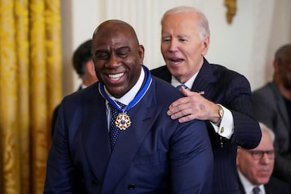 Earvin Magic Johnson recibe, agachado, la Medalla de la Libertad.