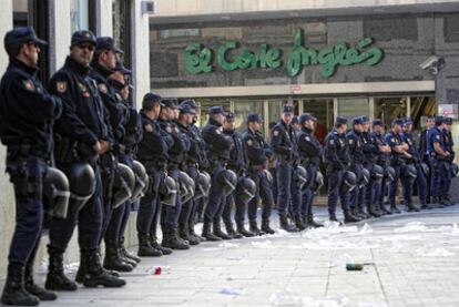 Un grupo de policías protege la entrada a unos grandes almacenes en la calle Preciados, en pleno centro de Madrid.