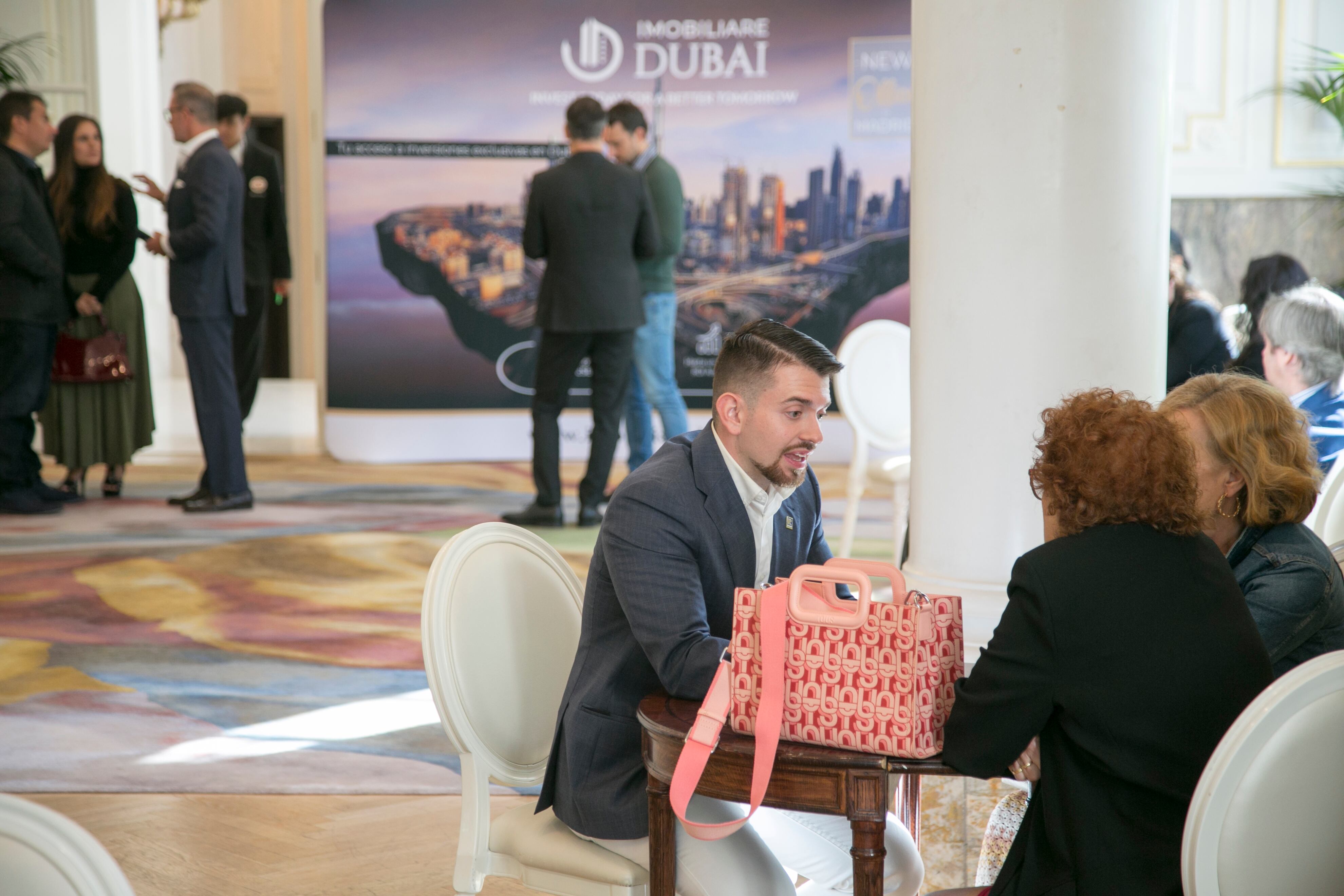 Un agente de Imobiliare Dubái, Álvaro Raya, habla el viernes 26 de septiembre con dos mujeres interesadas en comprar vivienda en el emirato, durante un evento en el hotel Mandarin Oriental Ritz, en Madrid.