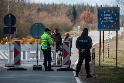 Un policía habla con una pareja ayer en la frontera entre Alemania y la República Checa.