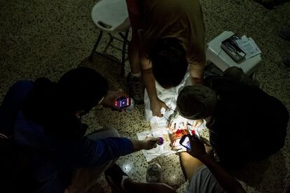 Un manifestante opositor al Gobierno de Nicolás Maduro es atendido después de ser herido durante enfrentamientos con miembros de la Policía Nacional Bolivariana (PNB), en el sector Chacao en Caracas (Venezuela).