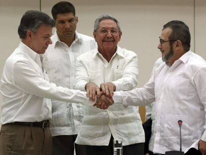 Santos y Timochenko se dan la mano ante Ra&uacute;l Castro.