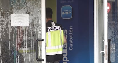 Un policía entra en la sede del PP de Castellón tras el lanzamiento de ácido y petardos contra la fachada.