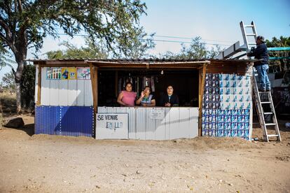 Irene, madre de Ceci, y dos de sus hijas, en el puesto de carretera donde venden semillas, refrescos y refrigerios. En un buen día de trabajo ganan 350 pesos (unos 16,5 euros). Una operación de labio en un centro privado puede costar alrededor de 1.800 euros.