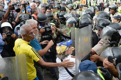 Varios manifestantes se enfrentan a la policía antidisturbios en Caracas.