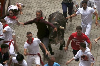 Un mozo corre delante de uno de los toros de la ganadería madrileña de Victoriano del Río a su llegada al callejón.