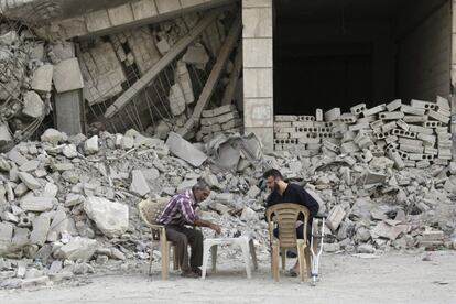 Dos hombres juegan al ajedrez frente a un edificio dañado en el área rebelde en la ciudad de Maaret al-Naaman (Siria).