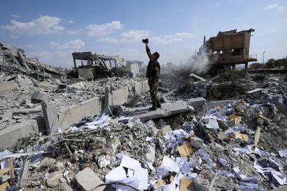 Un soldat sirià sobre les ruïnes d'uns dels centres d'investigació atacats pels EUA.