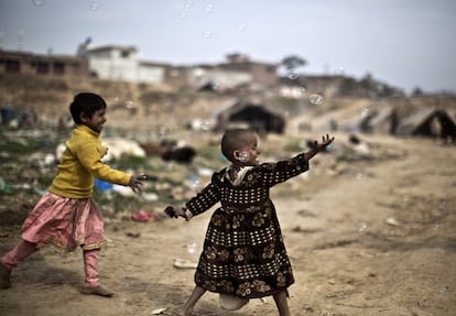 Unas niñas paquistaníes juegan con burbujas de jabón, en un barrio en Rawalpindi, Pakistán.