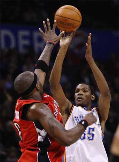 Kevin Durant, de los  Thunder de Oklahoma City, pelea un balón ante Jermaine O'Neal, de los Raptors.