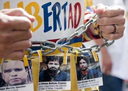 Un hombre muestra fotos de los policías secuestrados por las FARC en una multitudinaria protesta realizada contra esa guerrilla el pasado 6 de diciembre.