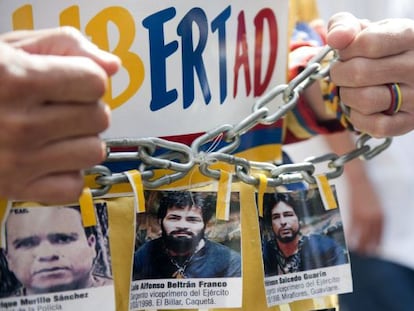 Un hombre muestra fotos de los polic&iacute;as secuestrados por las FARC en una multitudinaria protesta realizada contra esa guerrilla el pasado 6 de diciembre.