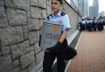 Un policia local arriba a la seu del Govern amb material antidisturbis.