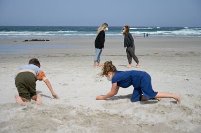 Dos niños y dos mujeres llevan mascarilla en la Playa das Salseiras, en el municipio de A Laracha, A Coruña, Galicia (España).