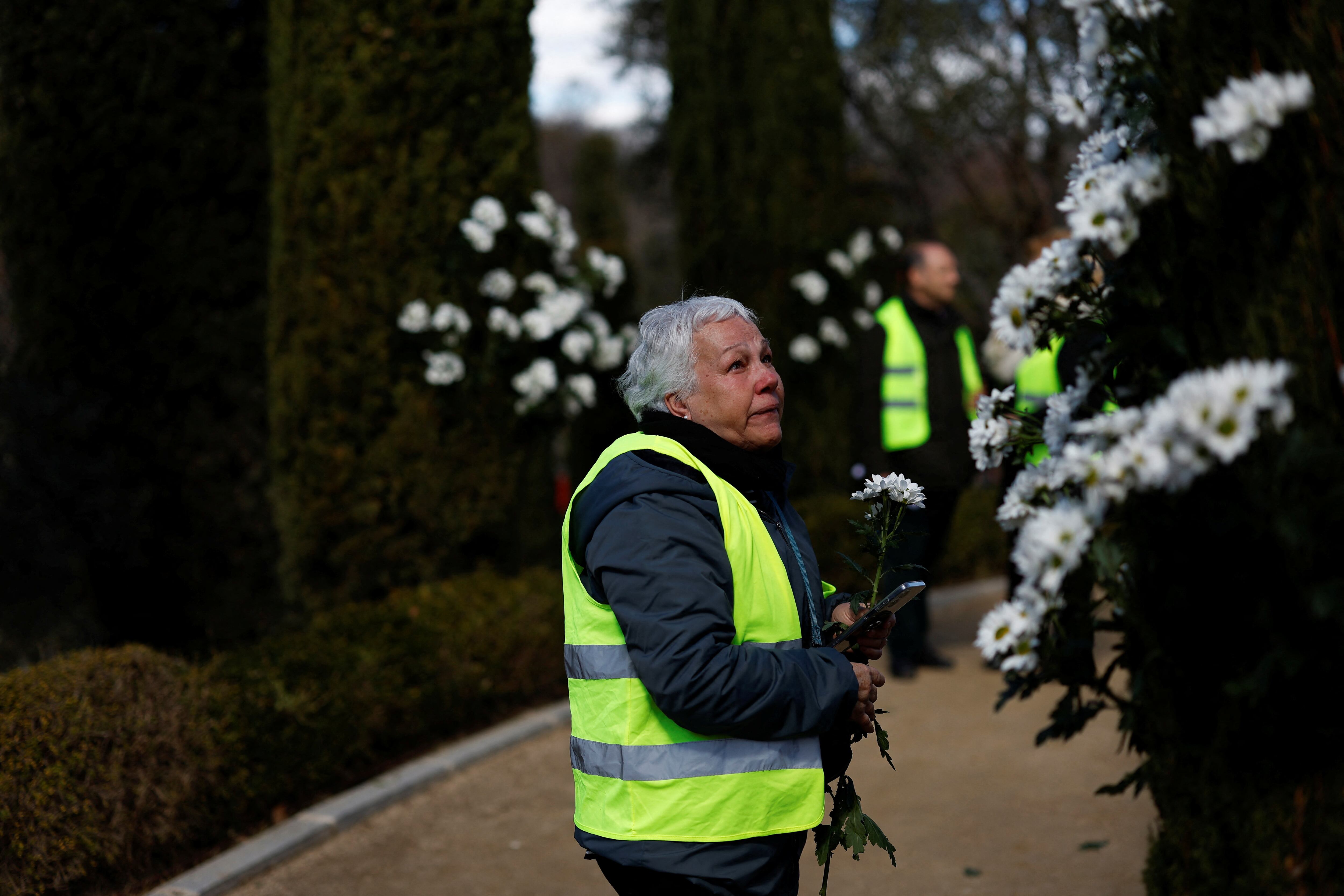 Una mujer sujeta flores durante el acto de homenaje celebrado por las víctimas de los atentados del 11-M, este lunes en el Bosque del Recuerdo del parque de El Retiro.