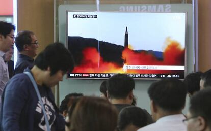 Varias personas observan en televisión la información sobre el lanzamiento de misil de Corea del Norte, este domingo.