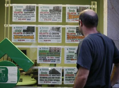 Un hombre ante el escaparate de una inmobiliaria.