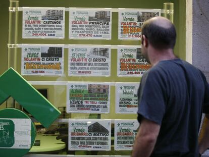 Un hombre ante el escaparate de una inmobiliaria.