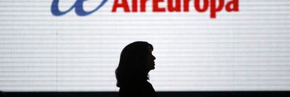 Una mujer pasa ante una pantalla con el logotipo de Air Europa en al terminal 2 de Barajas.