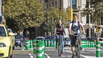 Dos personas, durante un trayecto por un carril bici segregado en Barcelona.