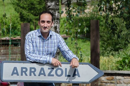 Juan Francisco Arrazola, sobre el panel que dirige a la antigua localidad de Arrazola, integrada ahora en el municipio de Atxondo (Vizcaya).