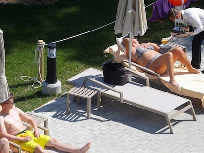 Un camarero atiende a una turista en la piscina de un hotel en Palma de Mallorca. 