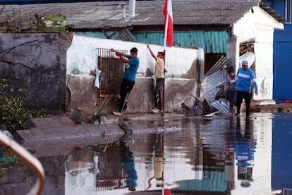 Un grupo de niños intentan cruzar una calle inundada entre los destrozos causados por el tsunami posterior al terremoto 8,4 de magnitud en la escala de Richter que anoche sufrió Chile, en el puerto de la localidad costera de Coquimbo (Chile), el 17 de septiembre de 2015.