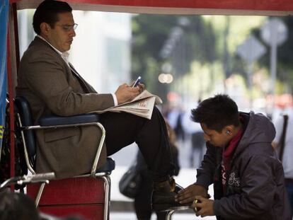 Un menor limpiabotas y su cliente en el DF.