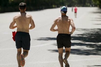 Dos hombres corren en el parque del Retiro de Madrid, con la ciudad en alerta amarilla por calor.