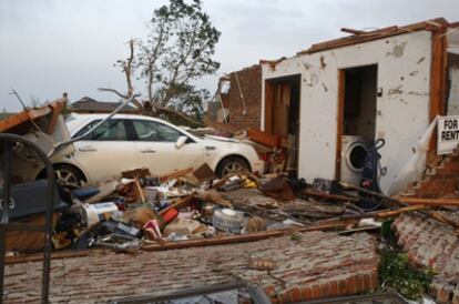 Un coche empotrado contra un garaje tras el paso del tornado en Piedmont, en Oklahoma.