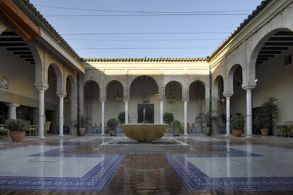 Uno de los patios del parador de Carmona, con arcos y una fuente en el centro.