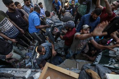 Palestinos recuperan un cuerpo de entre los escombros tras un ataque aéreo israelí en el campo de refugiados de Al-Maghazi, en la Franja de Gaza, este 19 de octubre de 2024.