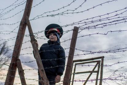 Matus, un muchacho eslovaco de siete años, lleva un sombrero militar soviético mientras permanece junto a los restos de las cercas fronterizas de la antigua "cortina de hierro" entre Eslovaquia y Austria, cerca de Bratislava (Eslovaquia).
