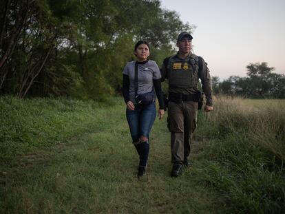 Un agente de la Patrulla Fronteriza escolta a una migrante de El Salvador después de que fuera detenida en Mission, Texas, el 13 de junio.