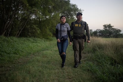 Un agente de la Patrulla Fronteriza escolta a una migrante de El Salvador después de que fuera detenida en Mission, Texas, el 13 de junio.