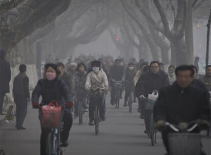 Ciclistas circulan con mascarillas por las calles de Nanjing.