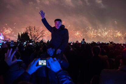 Un hombre posa ante una cámara mientras una multitud celebra el 75º aniversario del nacimiento de Kim Jong-Il en el centro de Pyongyang (Corea del Norte).